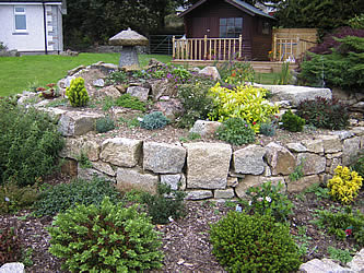 Rockery with granite boulders in garden