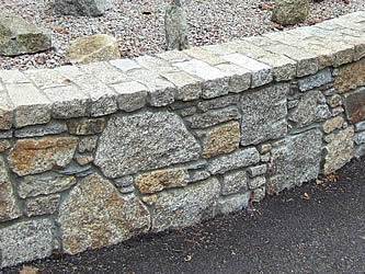 Granite setts laid as coping on garden wall